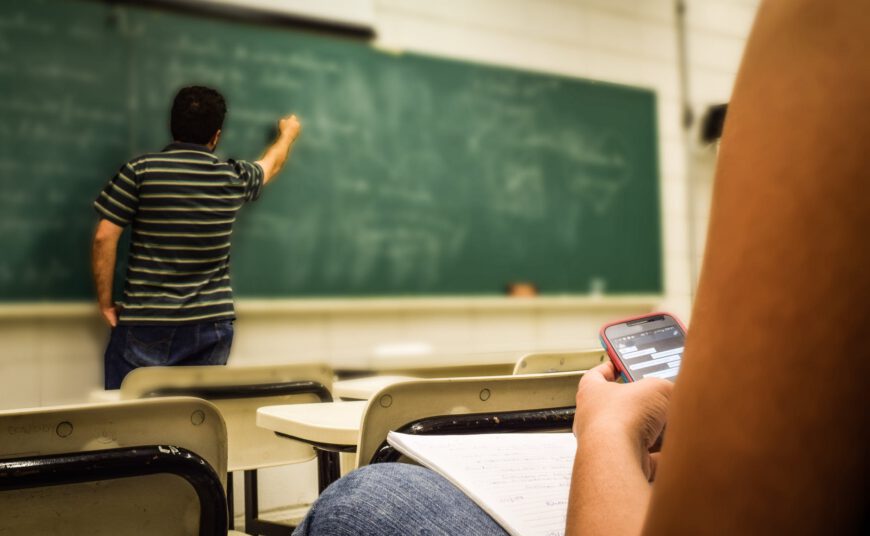 man in black and white polo shirt beside writing board